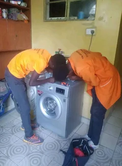 Technicians repairing a washing machine